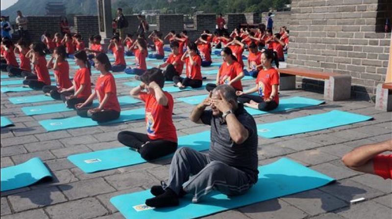 Minister of State for External Affairs VK Singh doing 'Bhramari Pranayam' (a breathing technique) along with others at The Great Wall of China, a day ahead of International Yoga Day, in Beijing on Tuesday. (Photo: AP) Minister of State for External Affairs VK Singh doing 'Bhramari Pranayam' (a breathing technique) along with others at The Great Wall of China, a day ahead of International Yoga Day, in Beijing on Tuesday. (Photo: AP)