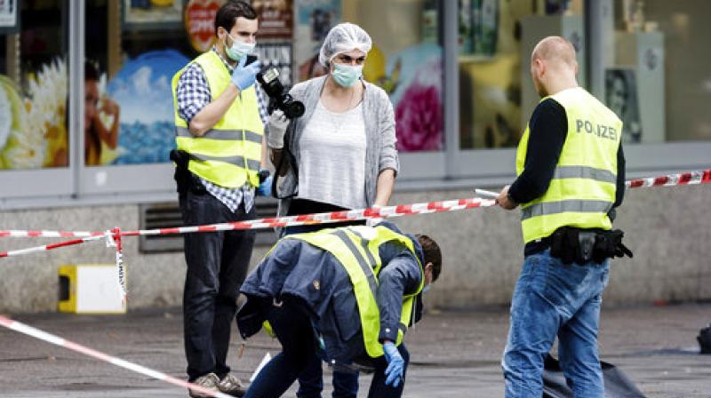 Police officers are securing evidence in front of the supermarket in Hamburg, Germany, where a man with a knife fatally stabbed one person and wounded four others as he fled, police said. He was then arrested. (Photo: AP) Police officers are securing evidence in front of the supermarket in Hamburg, Germany, where a man with a knife fatally stabbed one person and wounded four others as he fled, police said. He was then arrested. (Photo: AP)