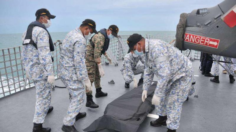 Malaysian Navy sailors cover an unidentified body on to the deck of KD Lekiu frigate after it was recovered in the waters off the Johor coast of Malaysia. (Photo: AP) Malaysian Navy sailors cover an unidentified body on to the deck of KD Lekiu frigate after it was recovered in the waters off the Johor coast of Malaysia. (Photo: AP)