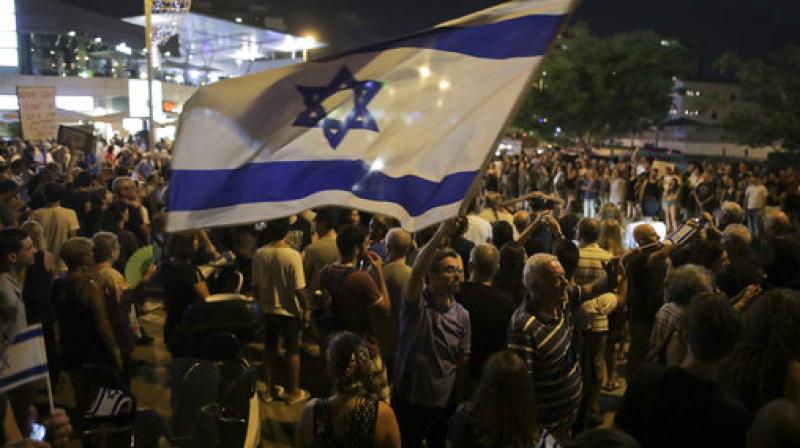 Israelis take part in a weekly protest against Israeli Prime Minister Benjamin Netanyahu, seen on the poster, in front of the home of Israel's attorney general Avichai Mandelblit in Petah Tikva. (Photo: AP) Israelis take part in a weekly protest against Israeli Prime Minister Benjamin Netanyahu, seen on the poster, in front of the home of Israel's attorney general Avichai Mandelblit in Petah Tikva. (Photo: AP)