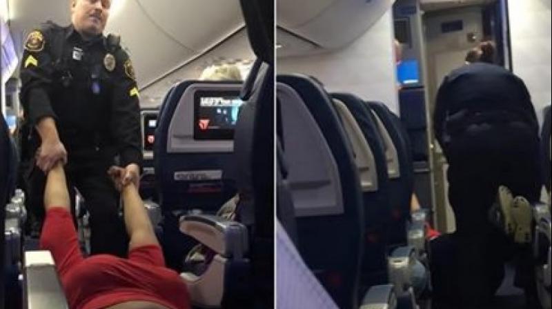 A short video clip of the incident shows police dragging the woman down the aisle by her arms while she lat flat on her back. (Credit: YouTube) A short video clip of the incident shows police dragging the woman down the aisle by her arms while she lat flat on her back. (Credit: YouTube)