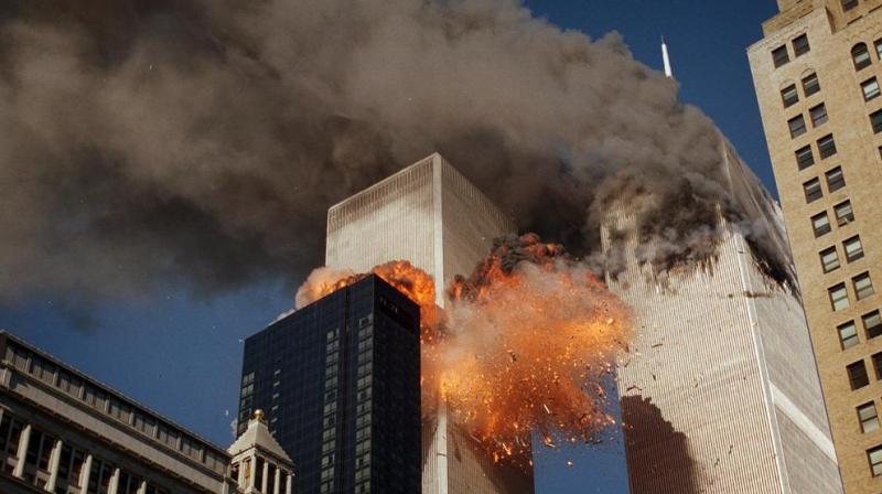 Smoke billows from one of the towers of the World Trade Center as flames and debris explode from the second tower, Tuesday, Sept. 11, 2001. (AP Photo/Chao Soi Cheong)