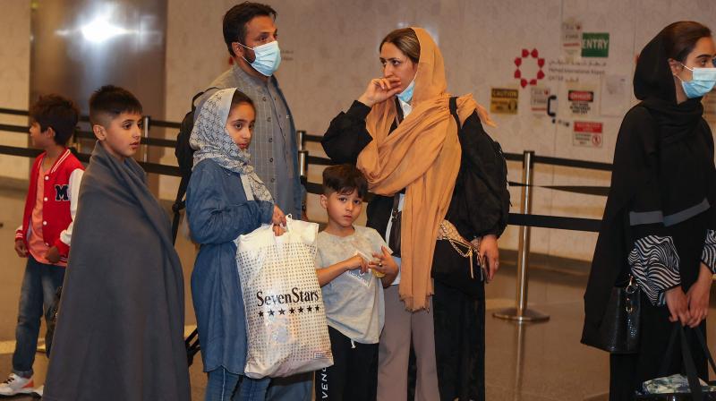 Evacuees from Afghanistan wait for passport checks upon arrival at Hamad International Airport in Qatars capital Doha on September 10, 2021. (KARIM JAAFAR / AFP)