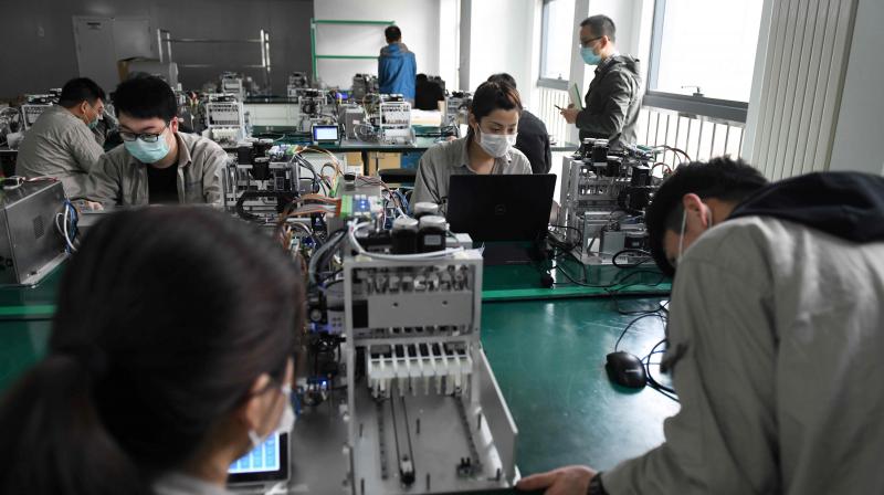 Technicians testing machines which can be used to analyze Covid19 coronavirus tests. AFP Photo Technicians testing machines which can be used to analyze Covid19 coronavirus tests. AFP Photo