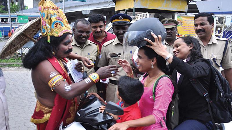 ‘Mahabali’ takes part in the traffic awareness campaign of the traffic cops in Kochi telling a woman two-wheeler driver who was riding the scooter without a helmet, about the virtue of wearing helmets at Edappally Junction in Kochi. —DC FILE PIC ‘Mahabali’ takes part in the traffic awareness campaign of the traffic cops in Kochi telling a woman two-wheeler driver who was riding the scooter without a helmet, about the virtue of wearing helmets at Edappally Junction in Kochi. —DC FILE PIC