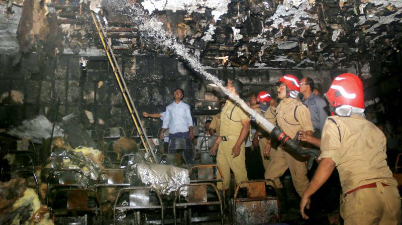 Fire force officials double-check burnt ceiling to ensure that the fire doesn't re-emerge from them at Padmanabha Theatre near East Fort on Thursday morning. (Photo: G.G. Abhijith) Fire force officials double-check burnt ceiling to ensure that the fire doesn't re-emerge from them at Padmanabha Theatre near East Fort on Thursday morning. (Photo: G.G. Abhijith)