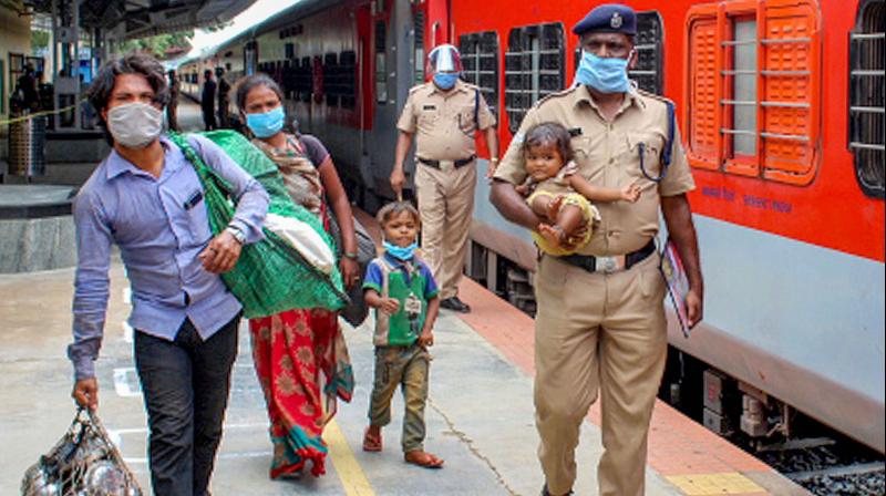 Police personnel help migrants board a train to their native places, during the ongoing COVID-19 nationwide lockdown, in Mysore. PTI Photo