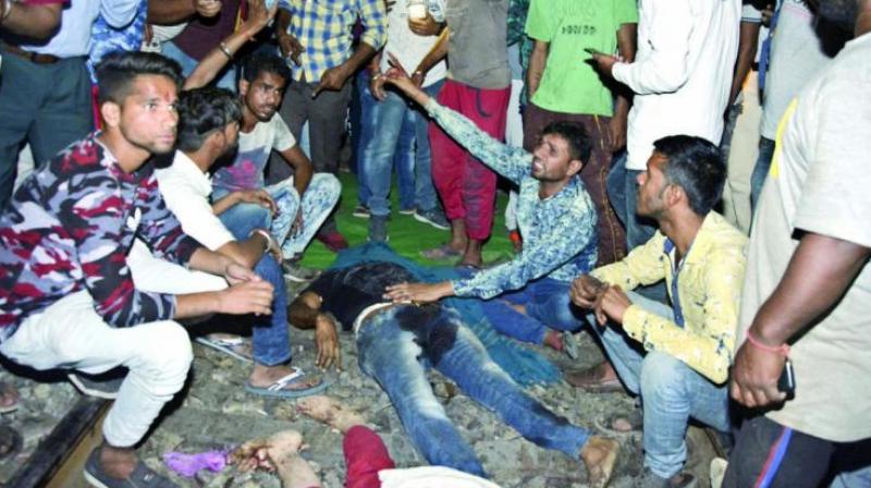 An angry crowd shout slogans as they sit by bodies of victims of the train accident in Amritsar on Friday. (Photo: AP) An angry crowd shout slogans as they sit by bodies of victims of the train accident in Amritsar on Friday. (Photo: AP)