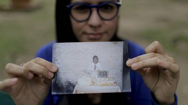 Karen Maydana shows a picture of herself as a child celebrating her first Holy Communion in Caseros. (Photo: AP) Karen Maydana shows a picture of herself as a child celebrating her first Holy Communion in Caseros. (Photo: AP)