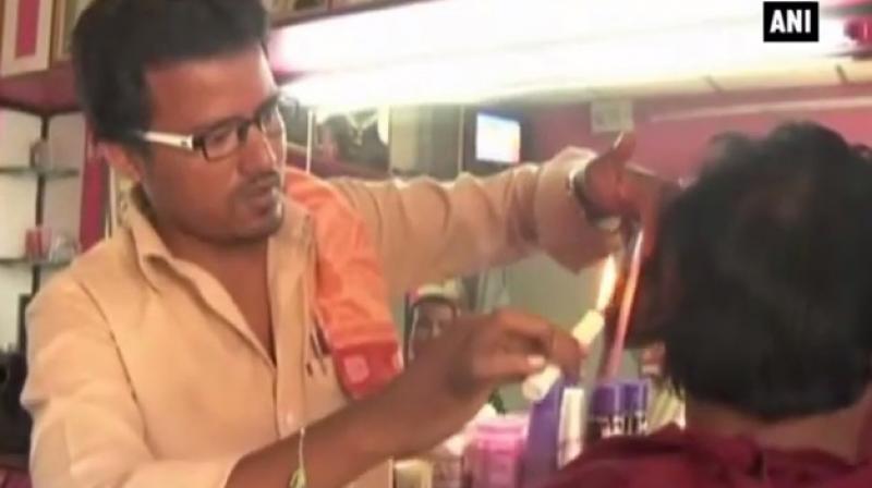 Dashrath, who runs Raj Men’s Salon in Gulbarga, in Karanataka wanted to experiment with the way he went about doing haircuts. (Credit: YouTube/ @ANI) Dashrath, who runs Raj Men’s Salon in Gulbarga, in Karanataka wanted to experiment with the way he went about doing haircuts. (Credit: YouTube/ @ANI)