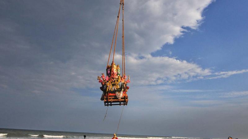 Crowds watch a JCB immerse a huge Ganesha idol in the sea near Pattinapakkam on Thursday (Photo: DC) Crowds watch a JCB immerse a huge Ganesha idol in the sea near Pattinapakkam on Thursday (Photo: DC)