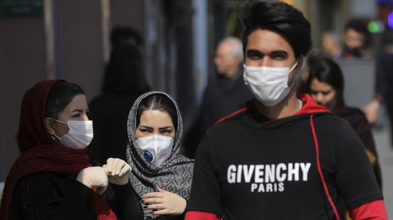 Pedestrians wear masks to help guard against the Coronavirus, in downtown Tehran, Iran. AP Photo