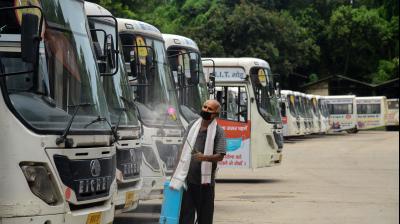 A worker sprays disinfectant on the buses parked at a depot during the total lockdown imposed to curb the spread of novel coronavirus, in Patna. PTI