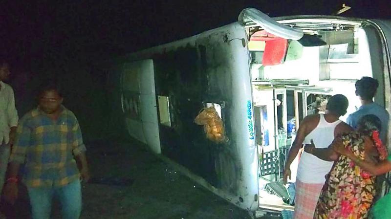 A private bus overturned at Laxminagaram in Khammam district in the wee hours of Monday. (Photo: DC) A private bus overturned at Laxminagaram in Khammam district in the wee hours of Monday. (Photo: DC)