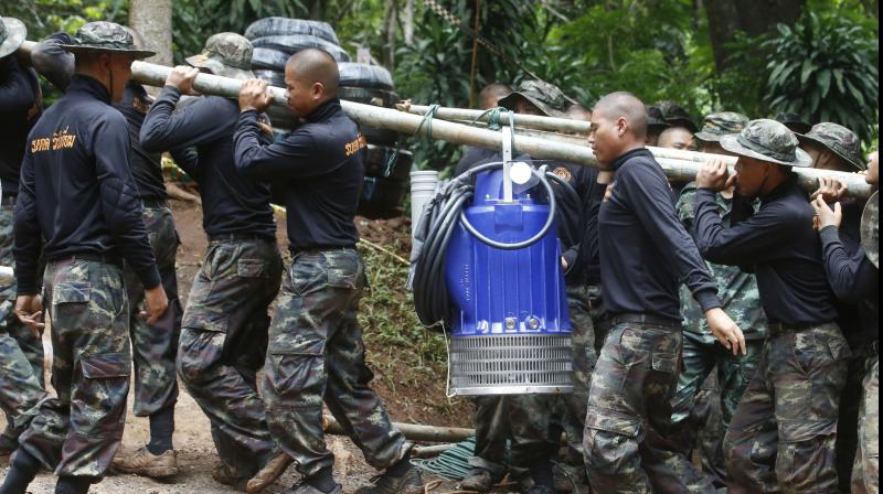 Soldiers carry a pump to help drain the rising flood water in a cave where 12 boys and their soccer coach have been trapped since June 23. Thai authorities are racing to pump out water from the flooded cave before more rains are forecast to hit the northern region. (Photo: AP) Soldiers carry a pump to help drain the rising flood water in a cave where 12 boys and their soccer coach have been trapped since June 23. Thai authorities are racing to pump out water from the flooded cave before more rains are forecast to hit the northern region. (Photo: AP)