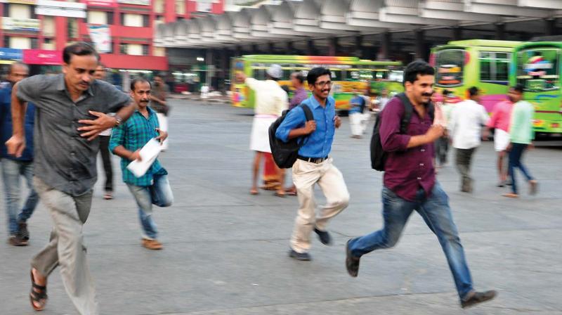 People run after a taxi at the New Bus Stand in Kozhikode on Saturday. (Photo: Venugopal) People run after a taxi at the New Bus Stand in Kozhikode on Saturday. (Photo: Venugopal)