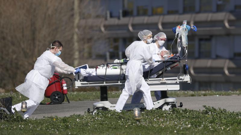 A victim of the COVID-19 coronavirus is evacuated by stretcher from the Mulhouse Civil Hospital in eastern France on March 23, 2020. The Grand Est region has become the epicentre of the outbreak in France. (AP) A victim of the COVID-19 coronavirus is evacuated by stretcher from the Mulhouse Civil Hospital in eastern France on March 23, 2020. The Grand Est region has become the epicentre of the outbreak in France. (AP)