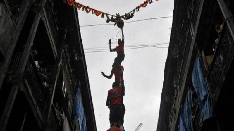 Dahi-Handi ritual is part of the Janmashtami festival in which youngsters, dressed in colourful costumes, make human pyramid to reach earthen pot having buttermilk, suspended in mid-air and break it. (Photo: ANI) Dahi-Handi ritual is part of the Janmashtami festival in which youngsters, dressed in colourful costumes, make human pyramid to reach earthen pot having buttermilk, suspended in mid-air and break it. (Photo: ANI)