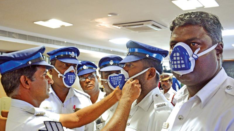 Traffic policemen try the N-95 mask distributed by Chennai police commissioner A.K. Viswanathan.