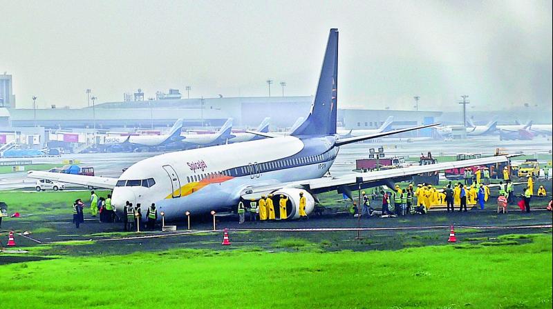 A SpiceJet plane from Jaipur overshot the runway while landing at the Mumbai airport amid heavy rain in Mumbai on Tuesday. Flight services at the Rajiv Gandhi International Airport were severely affected on Tuesday with airlines cancelling 203 services. (Photo: AP) A SpiceJet plane from Jaipur overshot the runway while landing at the Mumbai airport amid heavy rain in Mumbai on Tuesday. Flight services at the Rajiv Gandhi International Airport were severely affected on Tuesday with airlines cancelling 203 services. (Photo: AP)