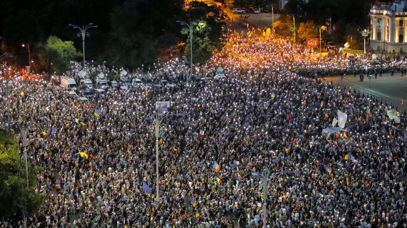 People shine the lights of their mobile phones during a protest outside the government headquarters, in Bucharest, Romania on Saturday. (Photo: AP) People shine the lights of their mobile phones during a protest outside the government headquarters, in Bucharest, Romania on Saturday. (Photo: AP)