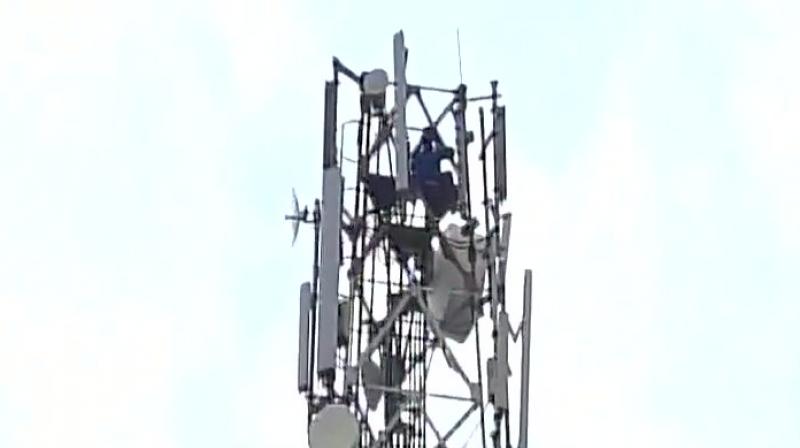 The man sent the whole town into a state of frenzy as he remained perched on the tower for four hours. (Photo: ANI | Twitter) The man sent the whole town into a state of frenzy as he remained perched on the tower for four hours. (Photo: ANI | Twitter)