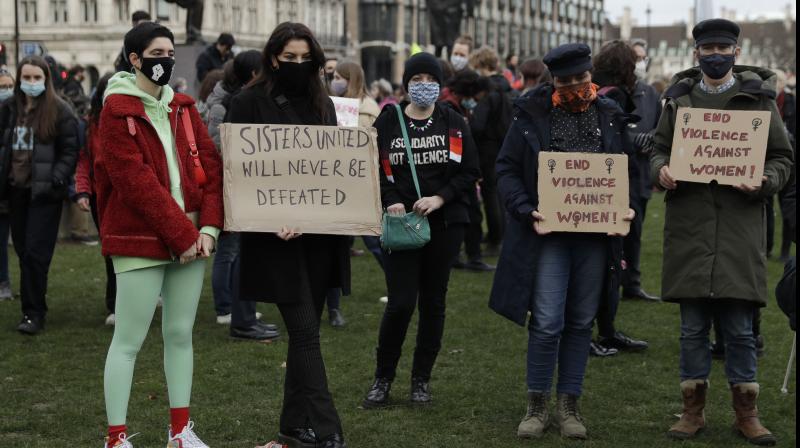 People hold up signs during a vigil to reflect on the murder of 33 year old marketing executive, Sarah Everard, in London, Monday, March 15, 2021. The British government is under pressure to do more to protect women and ensure the right to protest as Parliament prepares to debate a sweeping crime bill amid anger over the way police broke up a vigil for a young murder victim abducted on the streets of London. (AP/Matt Dunham)