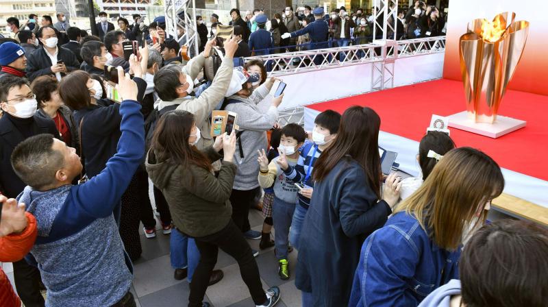 People gather to take a look at Olympic flame on display in Sendai, Miyagi prefecture, north of Tokyo Saturday, on Saturday. AP Photo