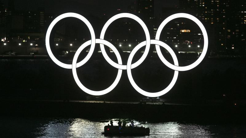 People in a small boat view the Olympic rings in the Odaiba section of Tokyo. AP Photo