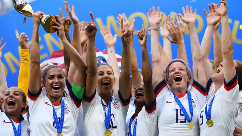 In this file photo, the United States womens football team celebrates with the France 2019 Womens World Cup trophy. The players were locked in a dispure with US Soccer Federation over equal pay with the American mens squad. AFP Photo