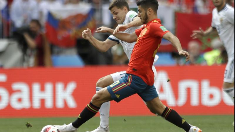 Spains Marco Asensio (front) and Russias Roman Zobnin challenge for the at the World Cup. AP Photo