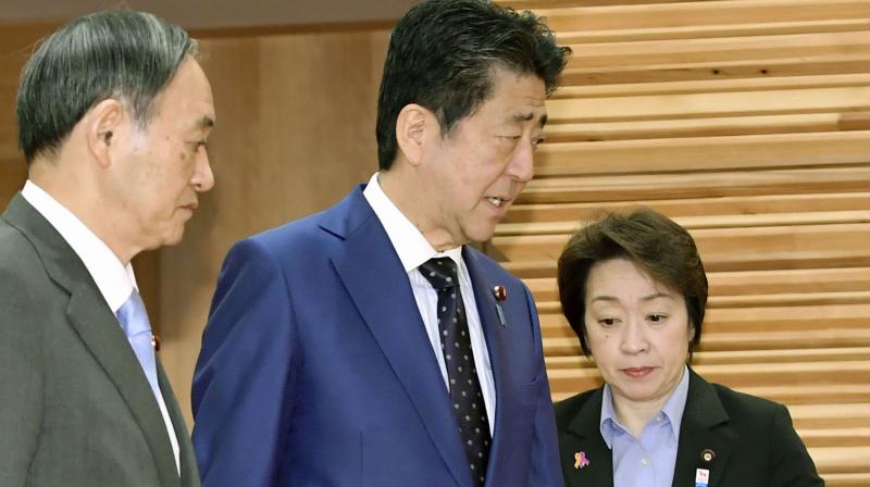 Japanese Prime Minister Shinzo Abe (C) with Olympic Minister Seiko Hashimoto (L) at a recent cabinet meeting. AP Photo