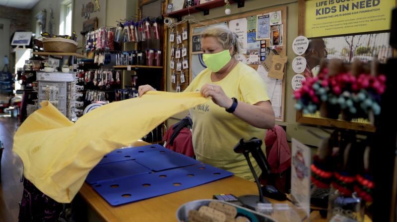 Amy Senter, owner of Jakes on Main, folds T-shirts in preparation for reopening her shop after being forced to close due to the coronavirus in St. Charles, Mo. (AP)