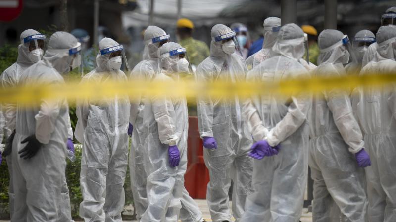 Immigration officers wearing full protection suits prepare at a coronavirus locked down area in Kuala Lumpur, Malaysia. (AP)