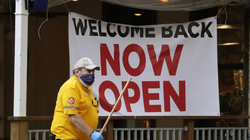 A worker passes a sign at a restaurant along the River Walk that has reopened in San Antonio. (AP)