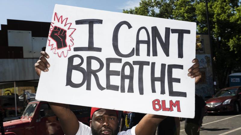 A man holds up a sign stating \I Cant Breathe\ at a memorial for George Floyd in Minneapolis, Minnesota. (AFP)