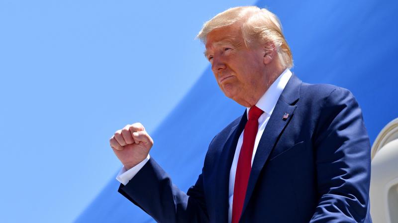 US President Donald Trump pumps his fist as he steps off Air Force One upon arrival in Dallas, Texas. (AFP)