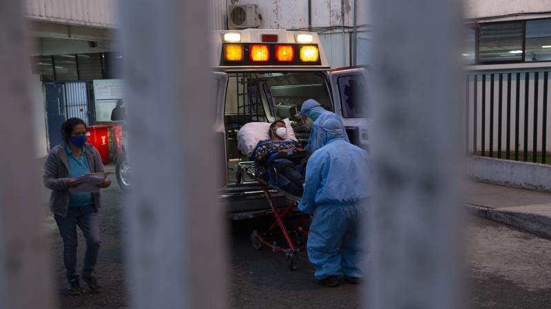 A patient with symptoms related to COVID-19 is brought to the coronavirus unit at San Juan de Dios hospital by firefighters in protective gear in Guatemala City. (AP)