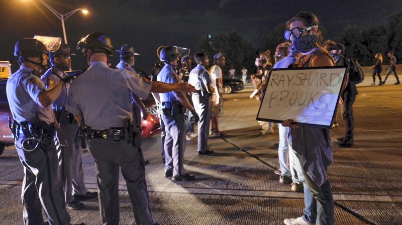 Demonstrators face police officers after getting onto I75 and shutting down the interstate in Atlanta. (AP) Demonstrators face police officers after getting onto I75 and shutting down the interstate in Atlanta. (AP)