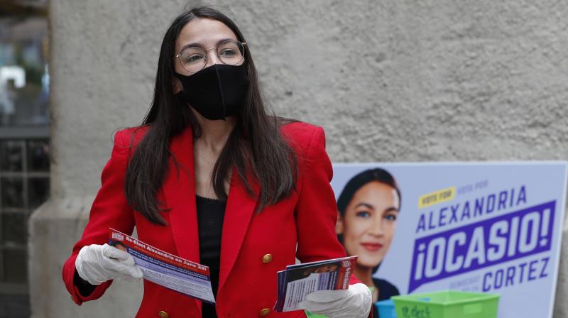 First-term U.S. Rep. Alexandria Ocasio-Cortez, D-New York, awaits passersby as she hands out leaflets explaining how to vote early or by absentee ballot during a stop at the Parkchester subway station in the Bronx borough of New York. (AP) First-term U.S. Rep. Alexandria Ocasio-Cortez, D-New York, awaits passersby as she hands out leaflets explaining how to vote early or by absentee ballot during a stop at the Parkchester subway station in the Bronx borough of New York. (AP)