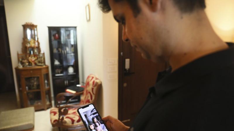 Karan Murgai, an IT management consultant for a multinational based in Dallas, shows on his phone in New Delhi, India, photograph of his daughters, who are in Dallas. (AP) Karan Murgai, an IT management consultant for a multinational based in Dallas, shows on his phone in New Delhi, India, photograph of his daughters, who are in Dallas. (AP)