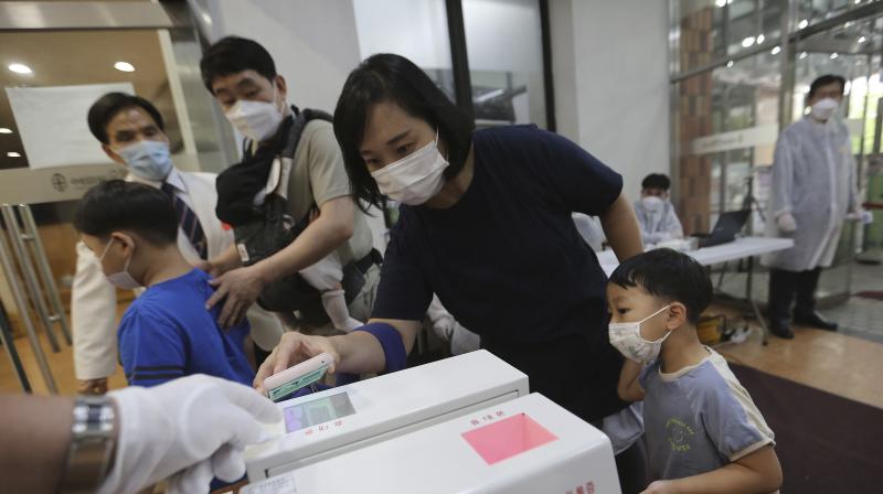 A Christian woman wearing a face mask to help protect against the spread of the new coronavirus scans a QR code on her smartphone before attending a service at the Yoido Full Gospel Church in Seoul, South Korea. (AP)