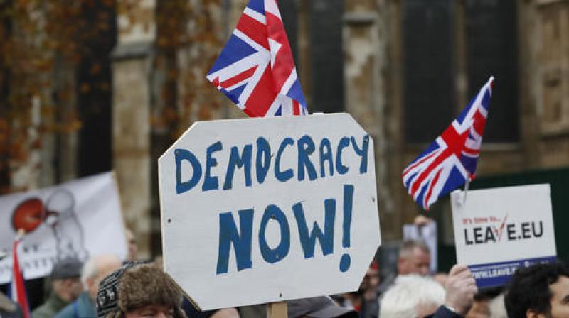 Pro-Brexit demonstrators wave flags and banners outside Parliament in London. (Photo: AP) Pro-Brexit demonstrators wave flags and banners outside Parliament in London. (Photo: AP)