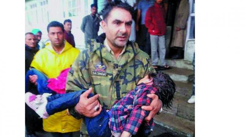 A policeman carries an injured child to a hospital after the cable-car snapped in Gulmarg in north Kashmir’s Baramulla district. (Photo: PTI) A policeman carries an injured child to a hospital after the cable-car snapped in Gulmarg in north Kashmir’s Baramulla district. (Photo: PTI)