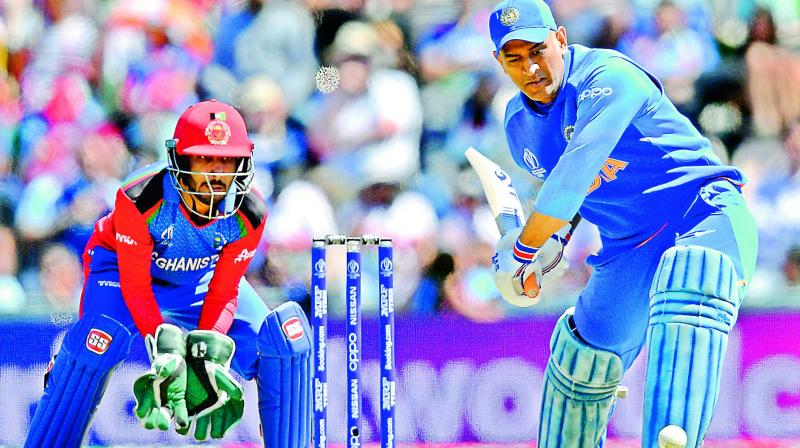 Mahendra Singh Dhoni (right) is watched by Afghanistan’s Ikram Ali Khil as he plays a shot during the 2019 Cricket World Cup group stage match between India and Afghanistan in Southampton. (AFP) Mahendra Singh Dhoni (right) is watched by Afghanistan’s Ikram Ali Khil as he plays a shot during the 2019 Cricket World Cup group stage match between India and Afghanistan in Southampton. (AFP)