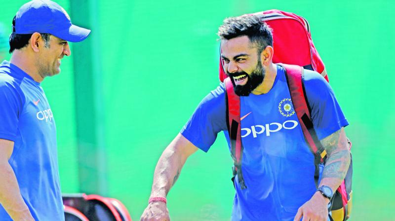 Mahendra Singh Dhoni (left) and Virat Kohli share a light moment at training. (Photo: AP) Mahendra Singh Dhoni (left) and Virat Kohli share a light moment at training. (Photo: AP)