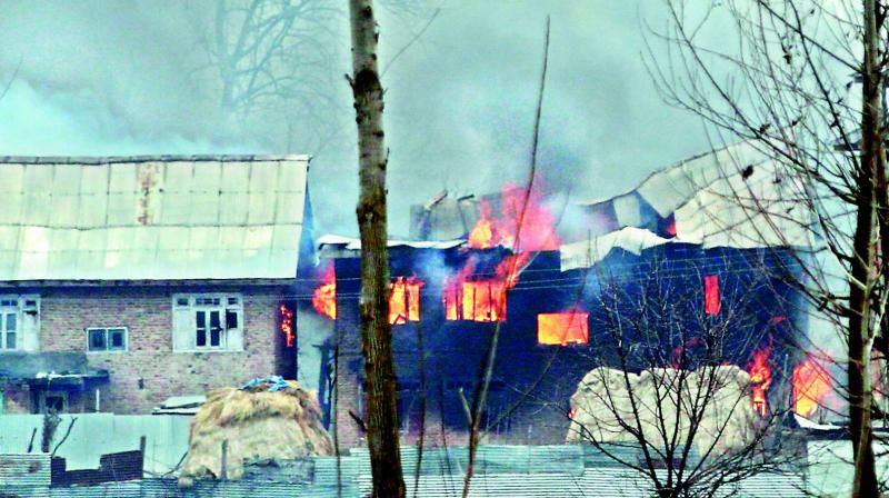 Flames and smoke rise from the house where two terrorists allegedly involved in the CRPF attack were said to be hiding, during an encounter with security forces, in Pinglena area of Pulwama district on Monday. (h.u. naqash) Flames and smoke rise from the house where two terrorists allegedly involved in the CRPF attack were said to be hiding, during an encounter with security forces, in Pinglena area of Pulwama district on Monday. (h.u. naqash)