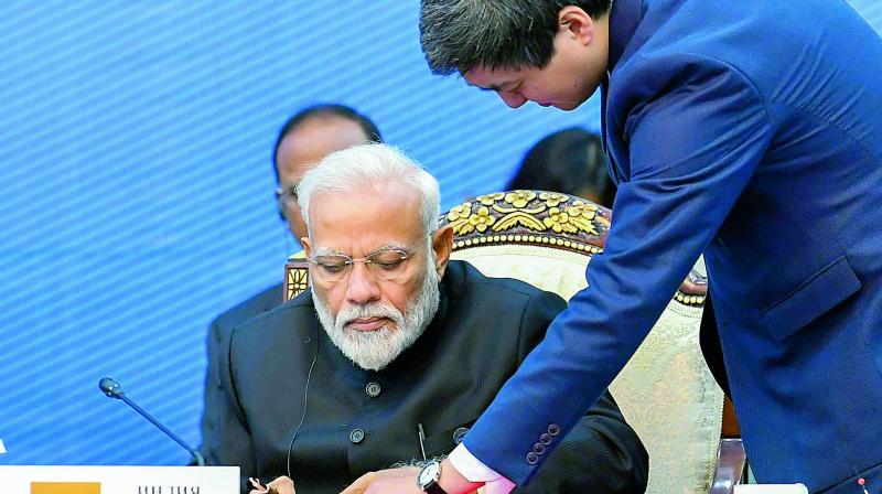 Prime Minister Narendra Modi signs documents at the Shanghai Cooperation Organisation Summit, in Bishkek on Friday. (PTI) Prime Minister Narendra Modi signs documents at the Shanghai Cooperation Organisation Summit, in Bishkek on Friday. (PTI)