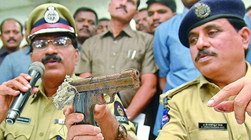 Hyderabad Commissioner of Police M. Mahender Reddy displays to the media the country-made pistol which was used in the shooting of Vikram Goud recently. The cops also seized cash worth Rs 5.3 lakh, one vehicle and eight mobile phones. (Photo:DC) Hyderabad Commissioner of Police M. Mahender Reddy displays to the media the country-made pistol which was used in the shooting of Vikram Goud recently. The cops also seized cash worth Rs 5.3 lakh, one vehicle and eight mobile phones. (Photo:DC)
