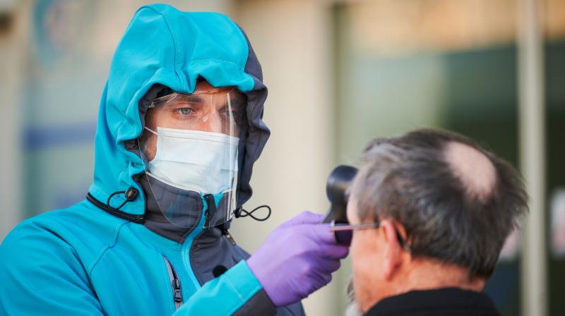 A medical worker measures body temperature at one of the entrances of the Community Health Centre in Kranj, Slovenia. AFP Photo A medical worker measures body temperature at one of the entrances of the Community Health Centre in Kranj, Slovenia. AFP Photo
